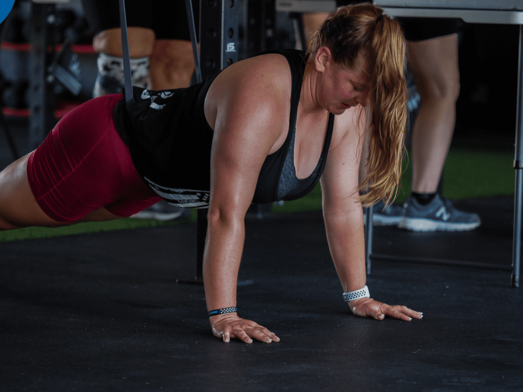 A woman is doing push ups in the gym.