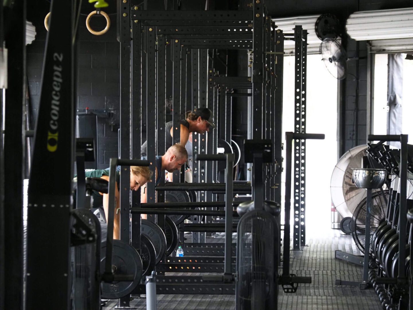 A man and two women working out in the gym.